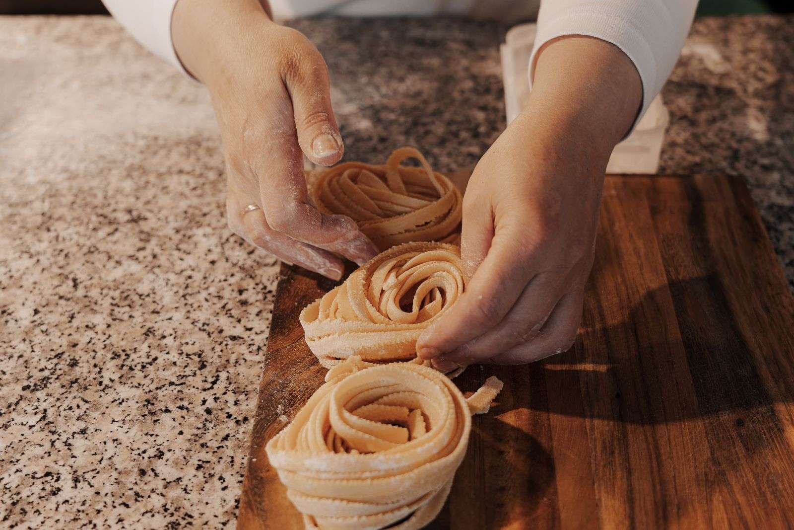 Tagliolini enrolado sobre tábua de madeira